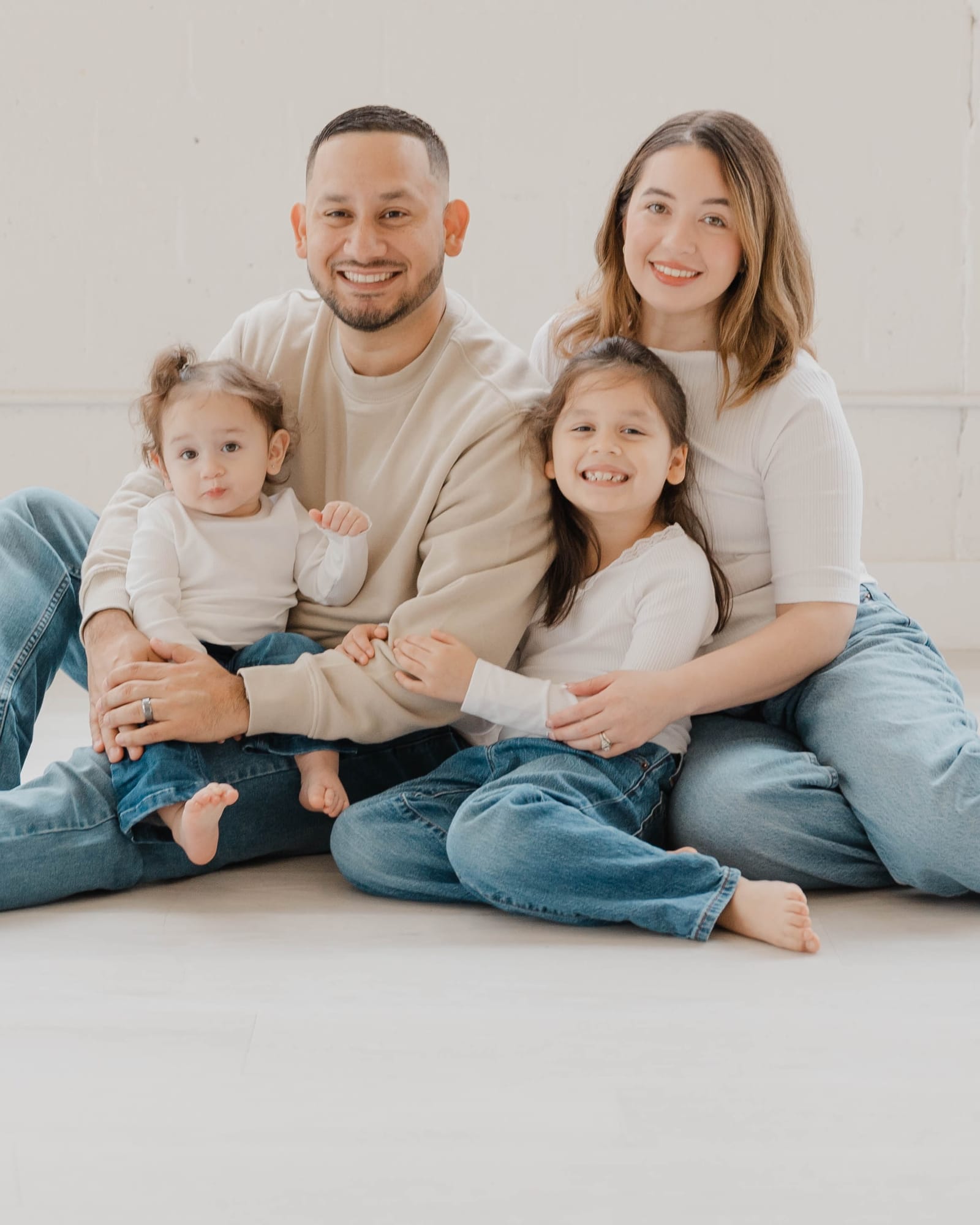 Isaiah sitting on a studio floor with his family